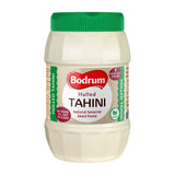 Jar of hulled tahini with green lid and label